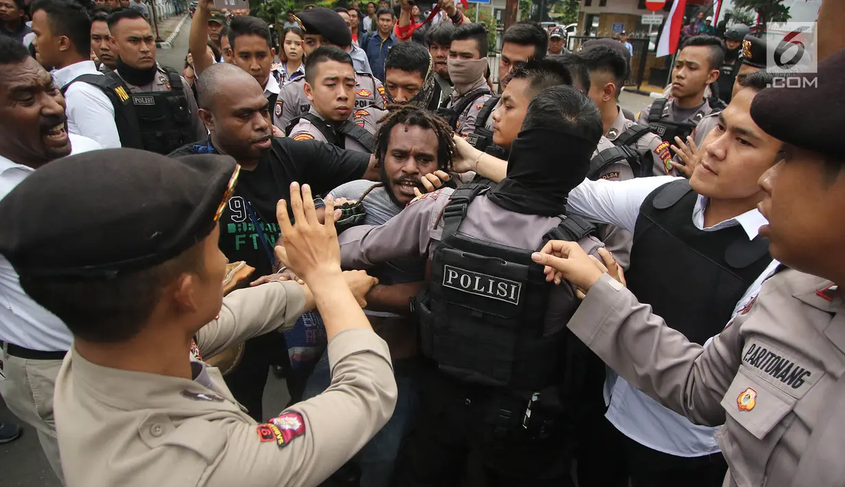 Polisi terlibat aksi saling dorong saat berusaha membubarkan massa FRI-WP dan AMP di Jalan Medan Merdeka Barat, Jakarta, Selasa (15/8). Kericuhan terjadi akibat polisi melarang aksi di depan Istana Negara. (Liputan6.com/Immanuel Antonius)