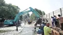 Pekerja menggunakan kendaraan alat berat saat menyelesaikan perbaikan tanggul jebol di Kompleks Perumahan Pantai Mutiara, Pluit, Jakarta, Minggu (7/6/2020). (Liputan6.com/Iqbal S. Nugroho)