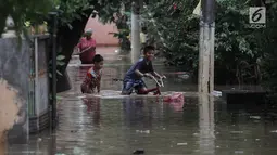 Anak-anak bermain air saat banjir merendam kawasan Cipinang Melayu, Jakarta Timur, Senin (5/2). Akibat hujan deras yang mengguyur sebagian besar wilayah Jakarta permukiman di Cipinang Melayu tergenang air setinggi 30-40 cm. (Liputan6.com/Arya Manggala)