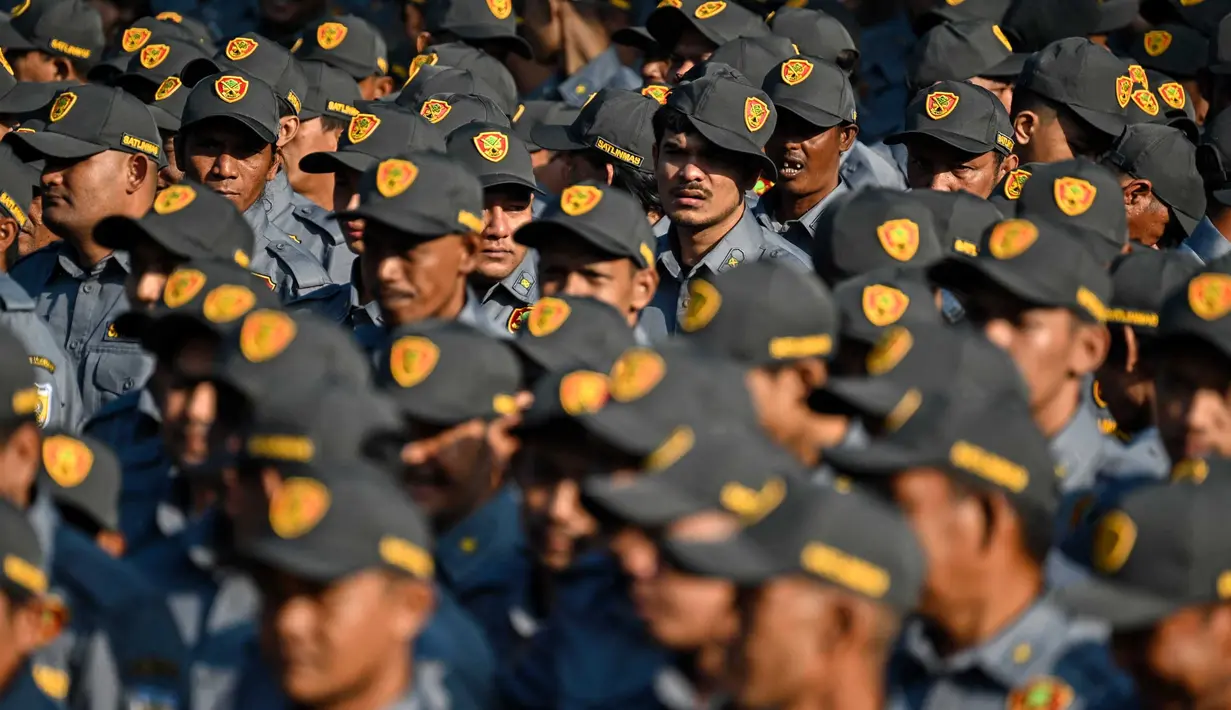 Anggota Satuan Perlindungan Masyarakat (LINMAS) mengambil bagian dalam apel pengamanan pemilu di Banda Aceh pada 8 Februari 2024. (CHAIDEER MAHYUDDIN/AFP)