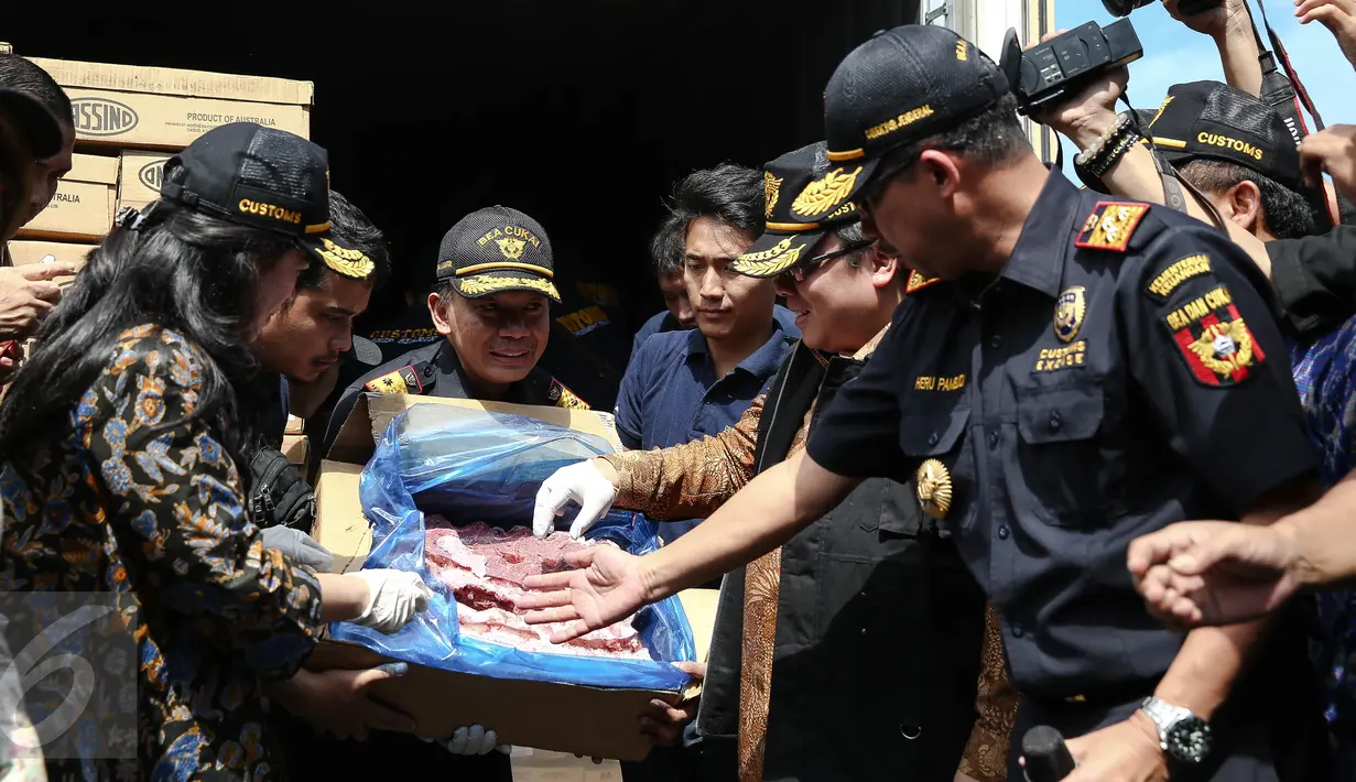 Dirjen Bea Cukai Heru Pambudi, Menkeu Bambang Brodjonegoro dan Menko PMK Puan Maharani menunjukkan daging sapi hasil sitaan asal Australia yang dihibahkan kepada masyarakat, di Tanjung Priok, Jakarta, Kamis (30/6). (Liputan6.com/Faizal Fanani)