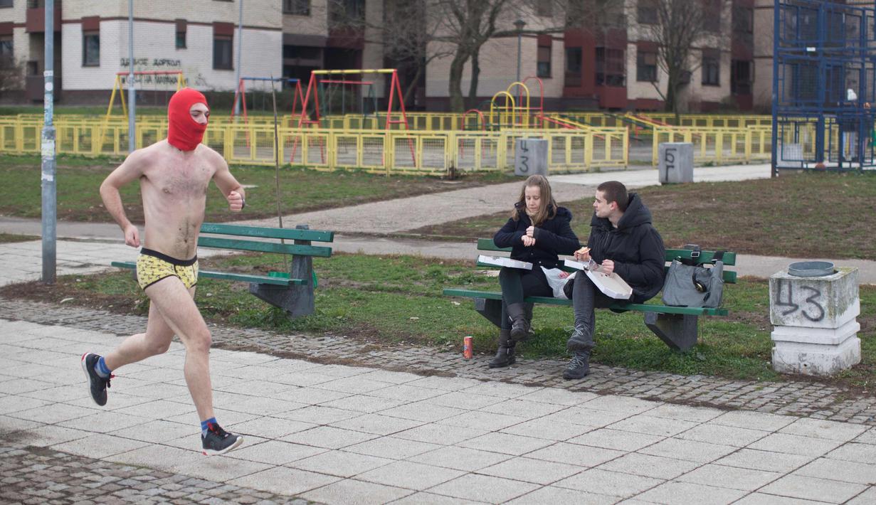 Seorang peserta pria mengenakan tutup wajah mengikuti lomba Underpants Run di tepi sungai Danube di Beograd, Serbia (4/2). (AP Photo/Marko Drobnjakovic)