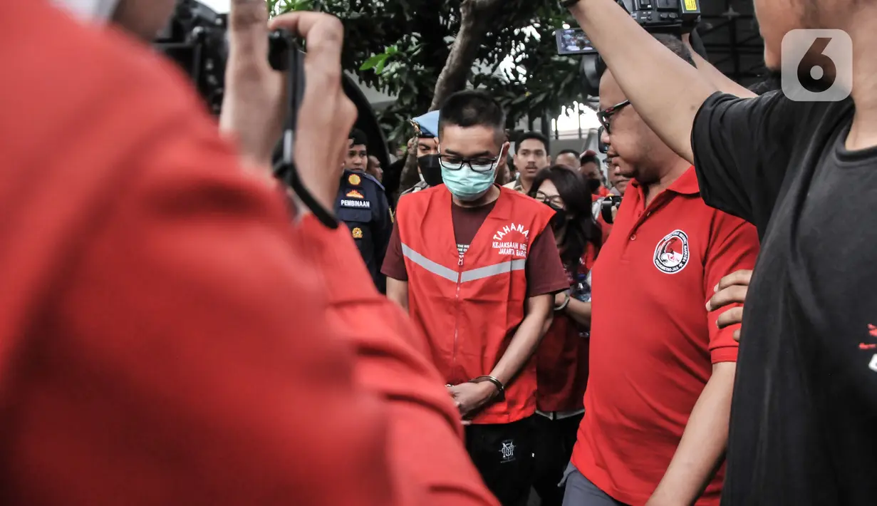 Tersangka lainnya mengenakan rompi merah Kejaksaan saat menuju mobil tahanan usai pelimpahan tahap II kasus narkoba di Kejaksaan Negeri Jakarta Barat, Rabu (11/1/2023). Penyidik Ditresnarkoba Polda Metro Jaya resmi melimpahkan berkas perkara kasus narkoba mantan Kapolda Sumatera Barat Irjen Pol Teddy Minahasa dan sejumlah tersangka ke Kejari Jakarta Barat. (merdeka.com/Iqbal S Nugroho)