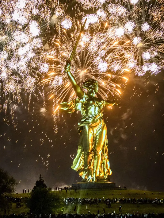 Sejumlah orang berkumpul di dekat patung The Motherland Calls yang dihiasi kembang api saat perayaan 73 tahun kemenangan Rusia dalam Perang Dunia II di Volgograd (8/5). (AFP/Mladen Antonov)