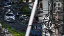 Kabel listrik dan kabel optik yang terlihat semrawut di kawasan Taman Puring, Jakarta, Jumat (3/7/2020). Kesemrawutan kabel ini sering terlihat di sejumlah kawasan Jakarta yang menyebabkan keindahan menjadi hilang dan pemandangan kurang enak untuk dilihat. (Liputan6.com/Johan Tallo)