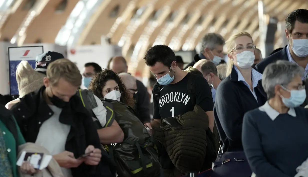 Penumpang menunggu untuk naik pesawat ke New York di bandara Charles de Gaulle, utara Paris, Senin (8/11/2021). AS pada Senin mencabut pembatasan perjalanan dari daftar panjang negara termasuk Meksiko, Kanada, dan sebagian besar Eropa. (AP Photo/Christophe Ena)