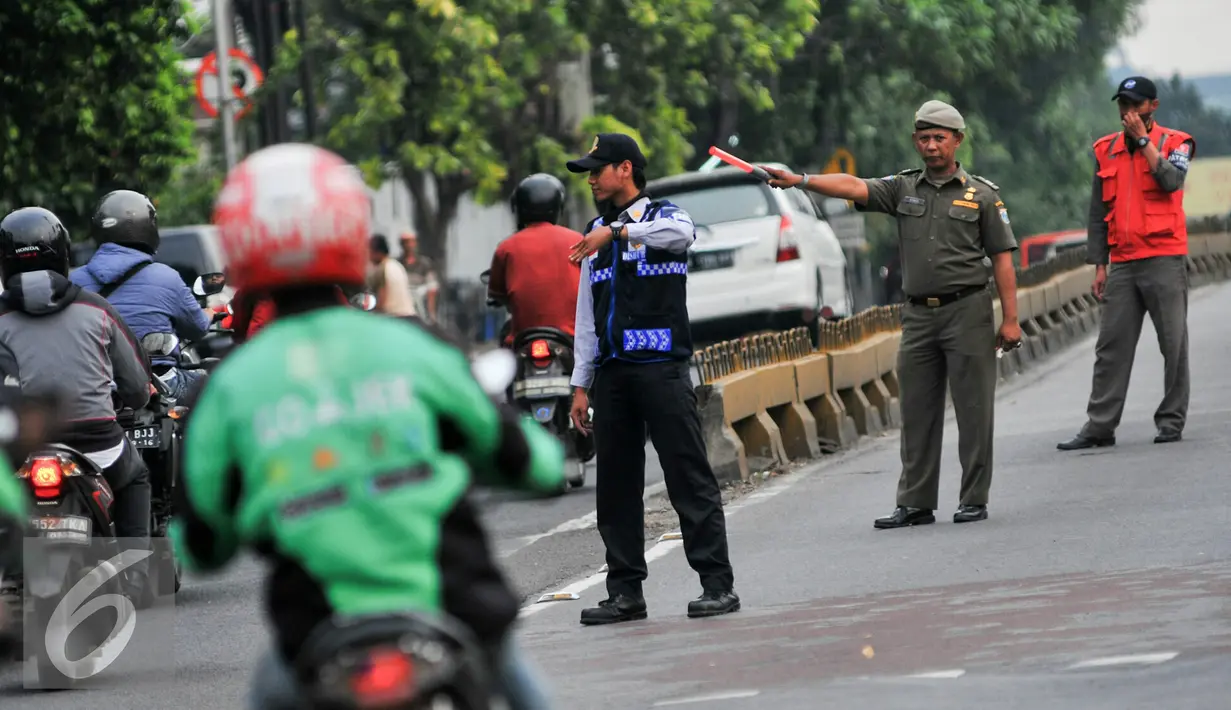 Petugas berjaga di jalur Transjakarta koridor 6  Dukuh Atas-Ragunan, Mampang Prapatan, Jakarta, Selasa (14/6/2016). Untuk menjaga jalur Transjakarta tetap steril, Dishub DKI Jakarta mengerahkan puluhan petugas. (Liputan6.com/Yoppy Renato)