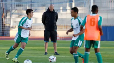 Pelatih Real Madrid Zinedine Zidane memperhatikan para pemain bola U14 dari tim Canton de Vaud, Lausanne, Senin (3/10). Zidane memimpin sesi latihan untuk seleksi tim Swiss, U14 Canton de Vaud. (REUTERS/Denis Balibouse) 