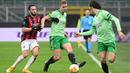 Gelandang AC Milan, Hakan Calhanoglu, berebut bola dengan gelandang Celtic, Kristoffer Vassbakk Ajer, pada laga lanjutan Liga Europa di Stadion San Siro, Jumat (4/12/2020) dini hari WIB. AC Milan menang 4-2 atas Celtic. (AFP/Vincenzo Pinto)