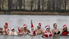 Anggota klub renang "Berliner Seehunde" (Berlin Seals) berendam di Danau Orankesee, Berlin, Minggu (25/12). Kegiatan yang sudah menjadi tradisi ini merupakan bagian dari perayaan tradisional Natal bagi warga Berlin. (Tobias SCHWARZ / AFP)