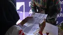 Petugas memeriksa Surat Tanda Registrasi Pekerja (STRP) bagi penumpang di Stasiun Tangerang, Banten, Senin (12/7/2021). Hari pertama penerapan STRP, masih ada warga yang tidak mengetahui persyaratan tersebut hingga membuat penumpang KRL menurun sekitar 30 persen. (Liputan6.com/Angga Yuniar)