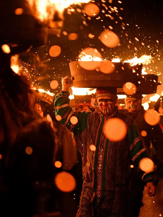 Festival ini melibatkan prosesi 45 pria yang membawa tong-tong berisi tar, serbuk gergaji, kayu bakar, dan parafin di kepala mereka. (Oli SCARFF/AFP)