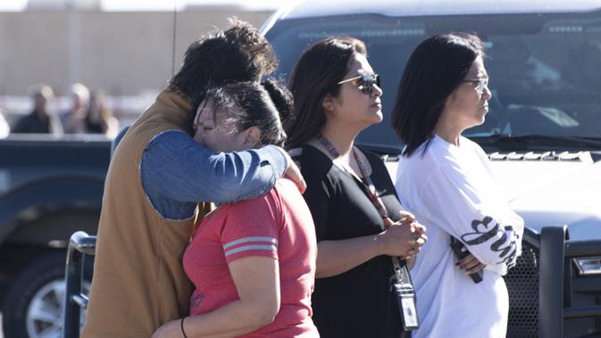 Keluarga menyaksikan polisi melakukan penyelidikan setelah penembakan di tempat parkir Walmart, Duncan, Oklahoma, Amerika Serikat, Senin (18/11/2019 ). Belum diketahui motif pelaku penembakan. (J Pat Carter/Getty Images/AFP)