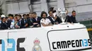 Para pemain Real Madrid menyapa fans saat merayakan kemenangan Liga Champions di Monumen Cibeles, Madrid, Minggu (27/5/2018). Real Madrid menggelar pawai kemenangan bersama fans usai menjuarai Liga Champions 2018. (AP/Francisco Seco)