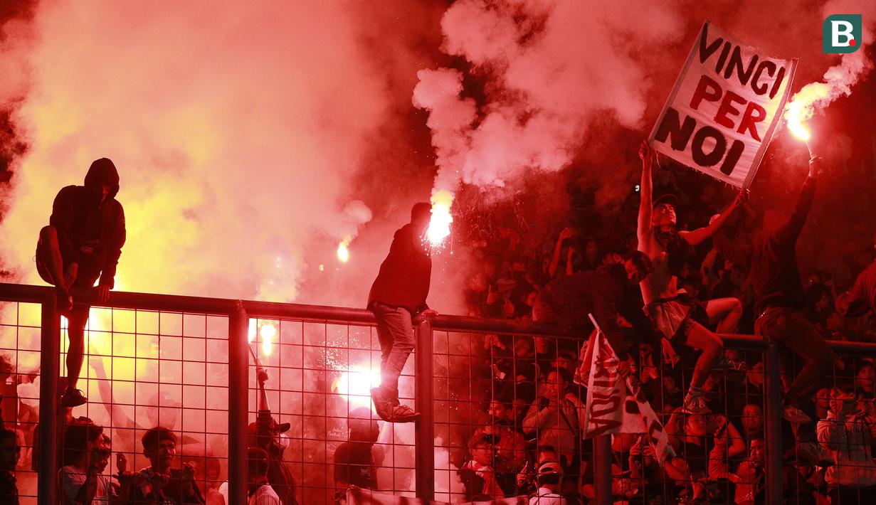 Suporter Timnas Indonesia memberikan dukungan kepada skuat Garuda dengan menyalakan suar saat laga uji coba internasional yang bertajuk FIFA Match Day antara Indonesia melawan Bangladesh di Stadion Si Jalak Harupat, Bandung, Rabu (01/06/2022). Pertandingan berakhir dengan skor kacamata. (Bola.com/M Iqbal Ichsan)