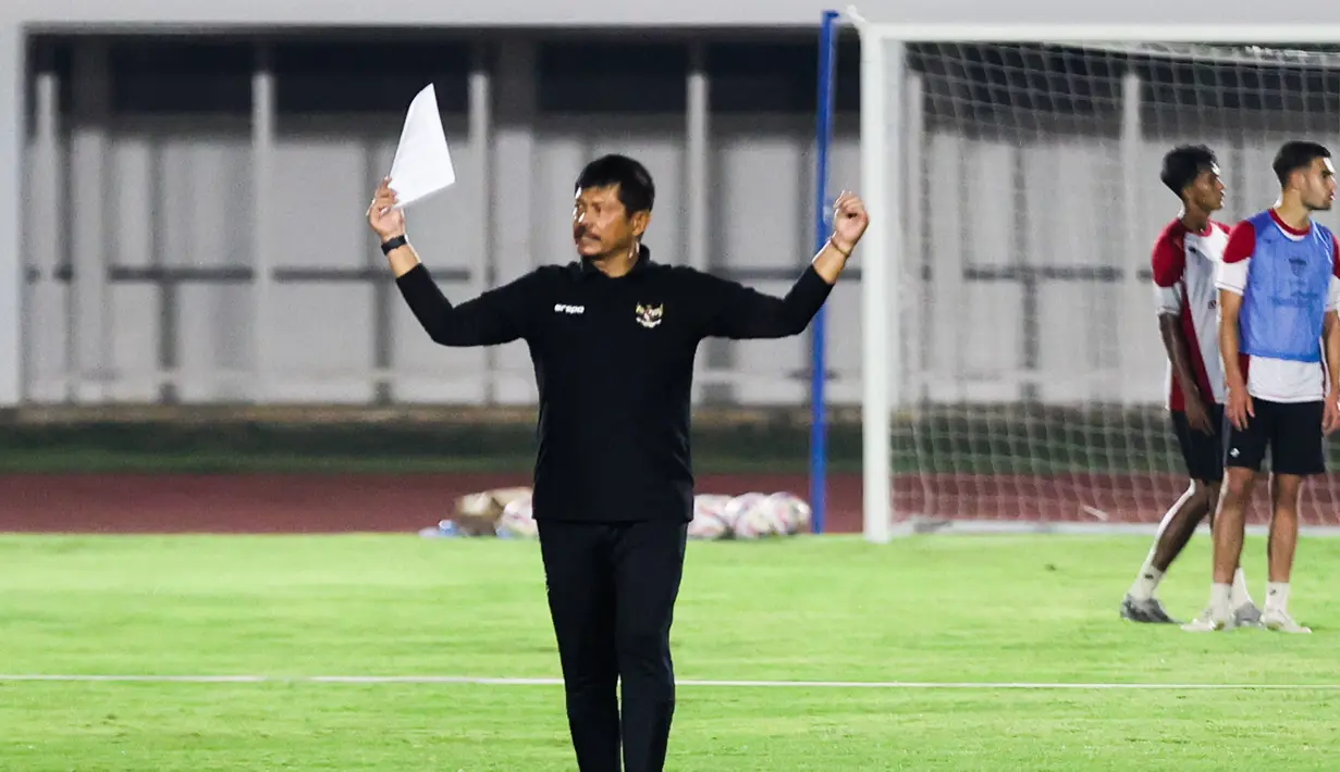 Indra Sjafri sedang memberikan instruksi dalam latihan Timnas Indonesia U-20 di Stadion Madya, Jakarta Pusat, pada Minggu (22/9/2024) malam WIB. (Bola.com/Abdul Aziz)