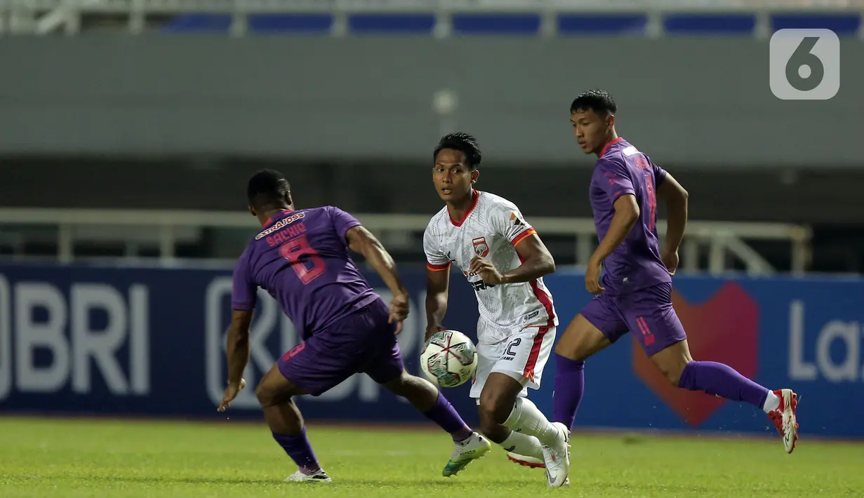 Pemain Borneo FC, Hendro Siswanto (tengah) berusaha melewati pemain Persik Kediri, Doe Sackie Teah (kiri) dalam pertandingan BRI Liga 1 2021/2022 di Stadion Pakansari, Bogor, Jumat (10/9/2021). Persik Kediri menang tipis atas Borneo FC 1-0. (Bola.com/Ikhwan Yanuar)