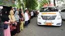 Warga berjajar melepas kepergian mobil jenazah yang membawa peti jenazah Asmaniah, istri Wakil Presiden ke-9 RI, Hamzah Haz di Jakarta, Selasa (12/9). Jenazah akan dimakamkan di pemakaman keluarga di Bogor, Jawa Barat. (Liputan6.com/Helmi Fithriansyah)