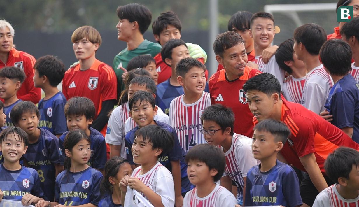 Wataru Endo, Yuto Nagatomo, dan sejumlah pemain Jepang bersiap foto bersama dengan sejumlah anak-anak yang tergabung ke dalam sekolah sepak bola Jakarta Japan Club (JJC) sebelum sesi latihan yang berlangsung di Lapangan A, Senayan, Jakarta, Selasa (12/11/2024). (Bola.com/Bagaskara Lazuardi)