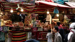 Sejumlah pedagang kurma menunggu pembeli di sebuah pasar di kota tua Sanaa, Yaman, Sabtu (11/5/2019). Kurma menjadi salah satu pilihan umat muslim sebagai menu buka puasa di bulan suci Ramadan. (Photo by Mohammed HUWAIS / AFP)