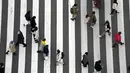 Orang-orang berjalan di sepanjang penyeberangan pejalan kaki di Tokyo (18/1/2022). Pemerintah Jepang sedang mempersiapkan pembatasan sosial di Tokyo dan wilayah lain karena varian omicron dari virus corona menginfeksi lebih banyak orang. (AP Photo/Eugene Hoshiko)
