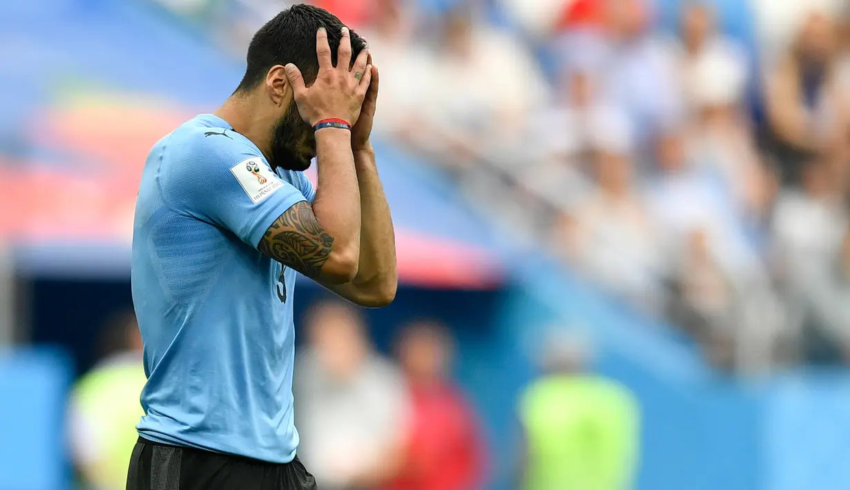 Striker Uruguay, Luis Suarez kecewa sambil menutupi wajah dengan tangan setelah kalah atas Prancis pada perempat final Piala Dunia 2018 di Nizhny Novgorod Stadium, Jumat (6/7). Timnas Uruguay tersingkir usai ditumbangkan Prancis 0-2. (AP/Martin Meissner))