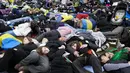 Orang-orang berbaring di tanah melambangkan mereka yang tewas dalam perang di Ukraina selama demonstrasi menentang invasi Rusia, dekat gedung parlemen Jerman, di Berlin, 6 April 2022. Pengunjuk rasa menuntut Berlin berhenti membeli minyak dan gas Rusia. (AP Photo/Markus Schreiber)