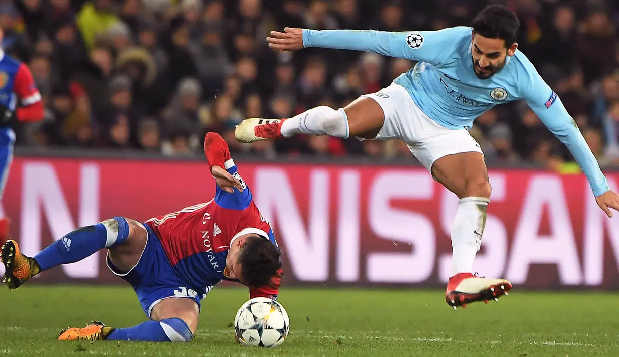 Gelandang Manchester City, Ilkay Gundogan berebut bola dengan pemain FC Basel, Taulant Xhaka pada leg pertama babak 16 besar Liga Champions di St. Jakob Park, Rabu (14/2). Manchester City memborong 4 gol tanpa balas di kandang Basel. (Patrick HERTZOG/AFP)