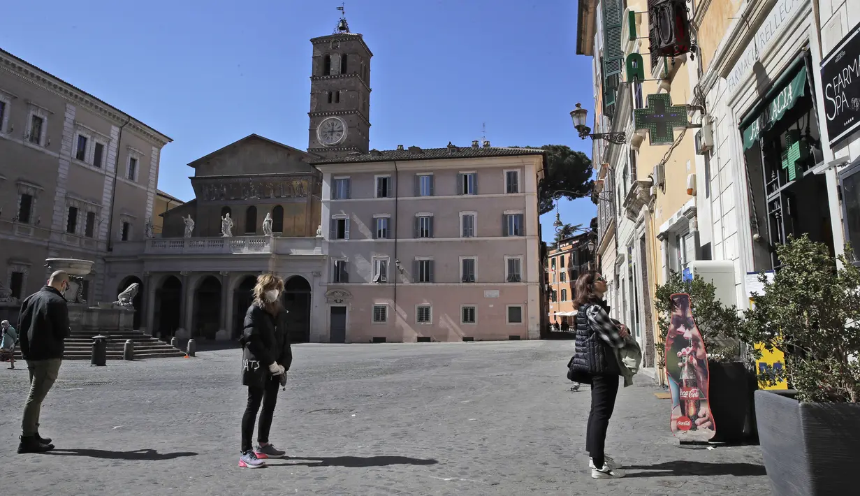 Warga melakukan social distancing atau menjaga jarak saat akan memasuki apotek di Roma, Italia, Senin (16/3/2020). Social distancing adalah cara terbaik untuk mencegah penyebaran virus corona COVID-19. (AP Photo/Alessandra Tarantino)