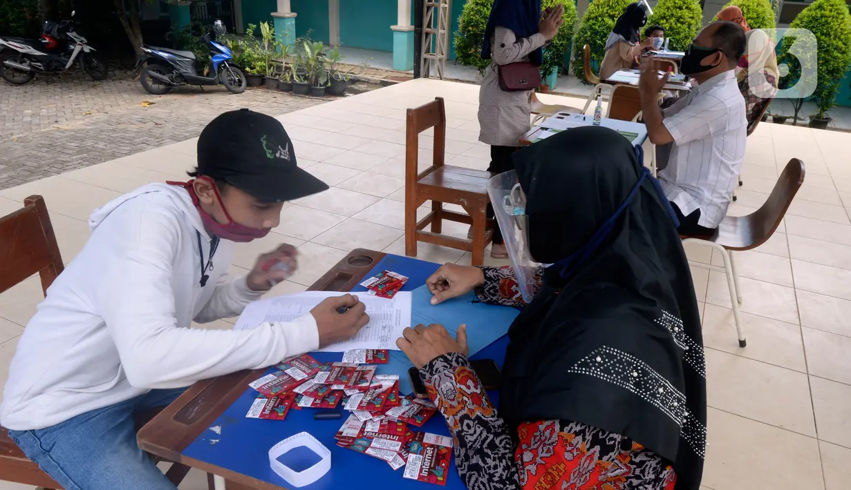 Guru membagikan kartu perdana Telkomsel dan Kuota 10 GB gratis kepada siswa kelas 7, 8 dan 9 SMPN 18, Pondok Benda, Pamulang, Tangsel, Kamis (10/9/2020). Program Kartu Perdana Merdeka itu untuk mendukung program pembelajaran jarak jauh (PJJ) di masa pandemi covid-19. (merdeka.com/Dwi Narwoko)