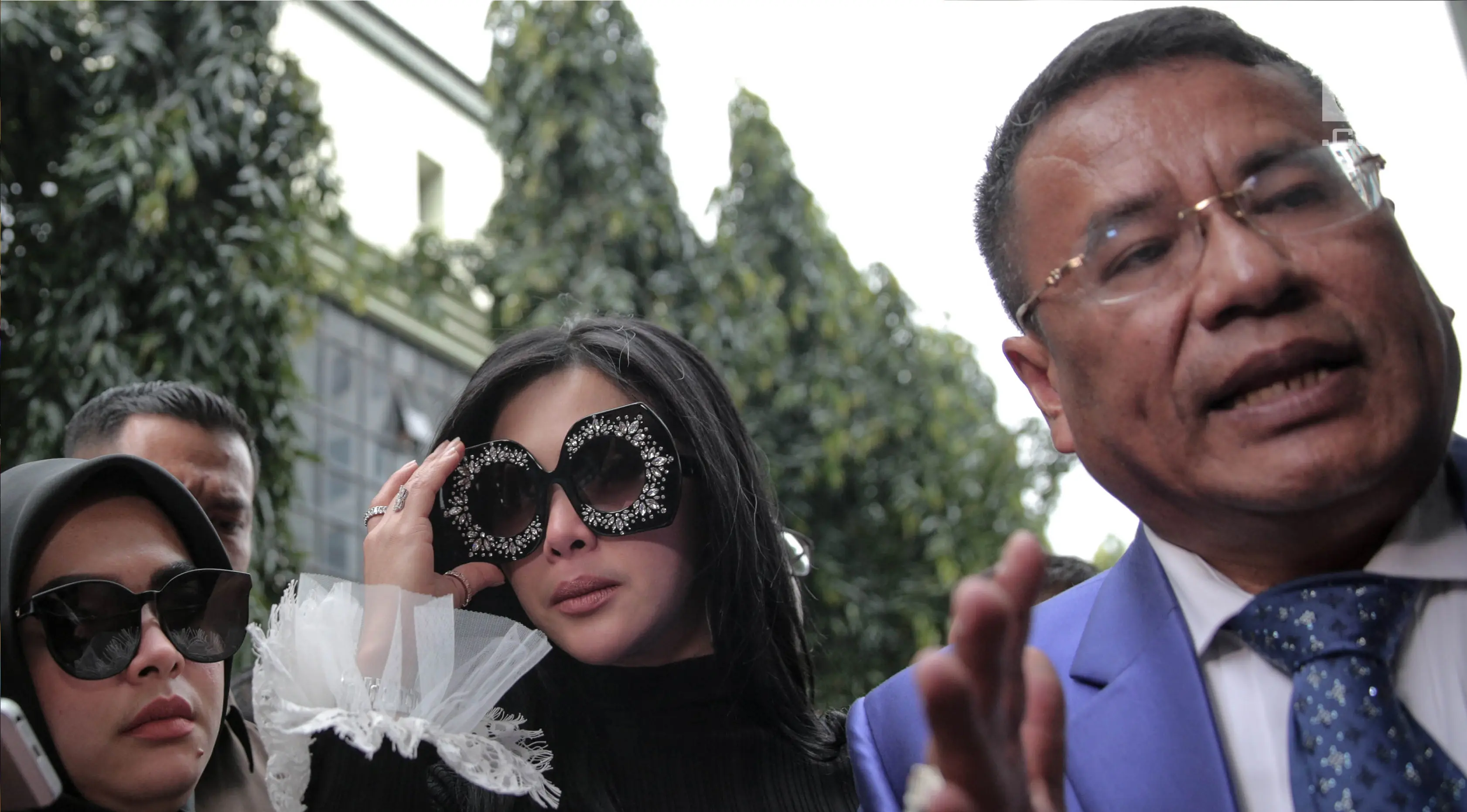 Penyanyi Syahrini memenuhi panggilan penyidik Bareskrim Polri, Jakarta, Senin (9/10). Syahrini kembali tampil nyentrik dengan kacamata hitam berlensa besar berhias kristal di bagian frame yang tersemat di kedua matanya. (Liputan6.com/Faizal Fanani)