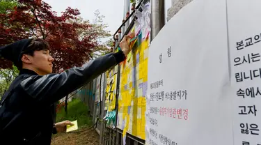 Beberapa pesan untuk mengenang para korban tenggelamnya kapal feri Sewol ditempelkan di gerbang utama Ansan Danwon High School, Korea Selatan, Senin (21/4/2014). (AFP PHOTO/KIM DOO-HO)