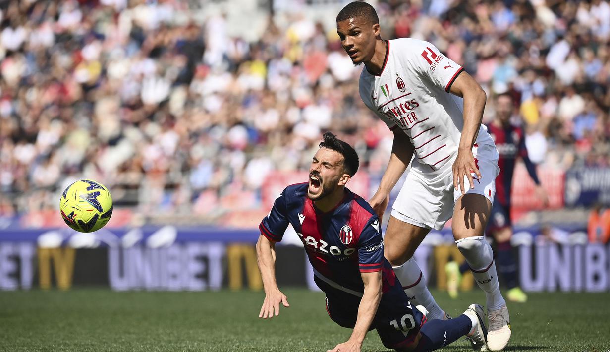 Pemain Bologna, Nicola Sansone (kiri) terjatuh saat berebut bola dengan pemain AC Milan, Malick Thiaw pada laga lanjutan Liga Italia 2022/2023 di Renato-Dall'Ara Stadium, Bologna, Minggu (16/04/2023) WIB. Laga berakhir dengan skor imbang 1-1. (AP Photo/LaPresse/Massimo Paolone)
