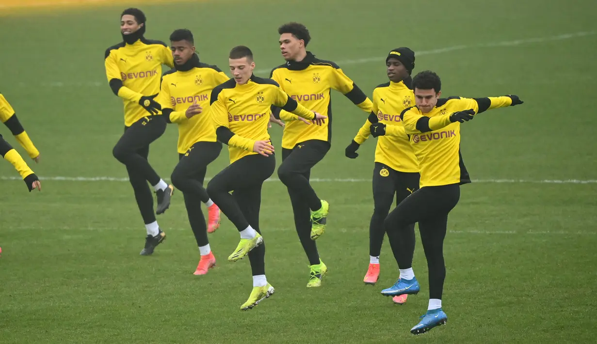Para pemain Borrusia Dortmund melakukan pemanasan selama sesi latihan di tempat latihan tim di Dortmund, Jerman barat (9/3/2021). Dortmund akan bertanding melawan Sevilla pada leg kedua babak 16 besar Liga Champions di Signal Iduna Park. (AFP/Ina Fassbender)