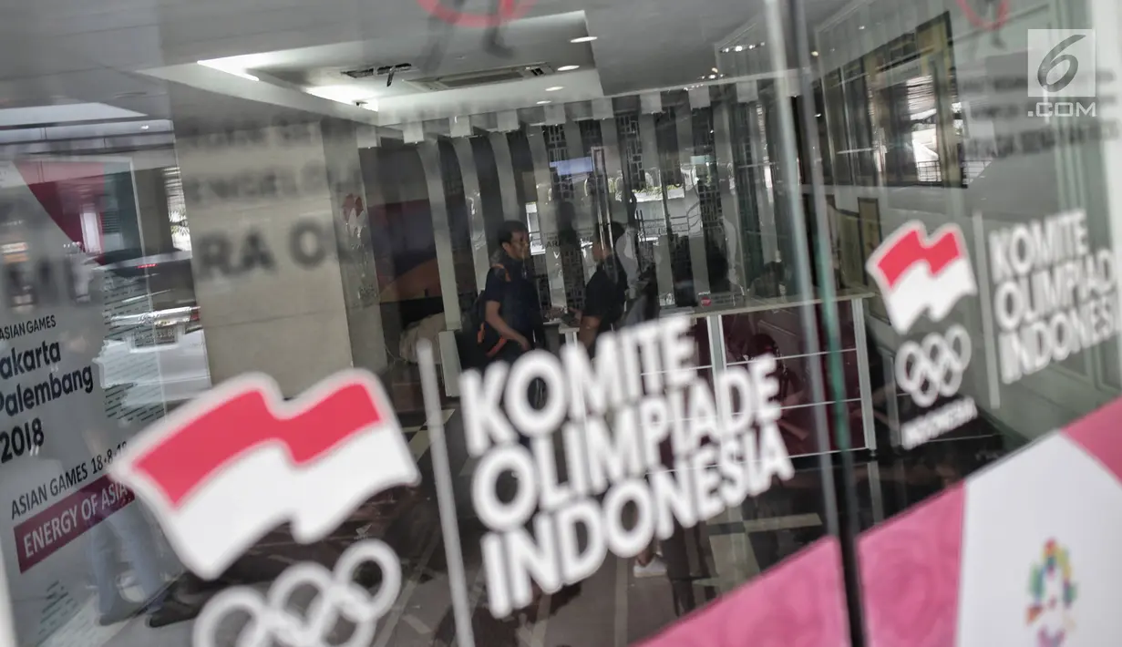 Sejumlah orang terlihat berada di dalam kantor PSSI saat penggeledahan oleh Satgas Antimafia Bola Polri di FX Office Tower, Jakarta, Rabu (30/1). Penggeledahan terkait kasus pengaturan skor sepak bola Indonesia. (Liputan6.com/Faizal Fanani)