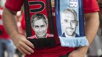 Seorang fans mengenakan slayer bergambar pelatih Manchester City,  Pep Guardiola (kanan) dan pelatih  Manchester United, Jose Mourinho,  pada laga Premier League di Old Trafford, Manchester,  (10/9/2016). (AFP/Oli Scarff)
