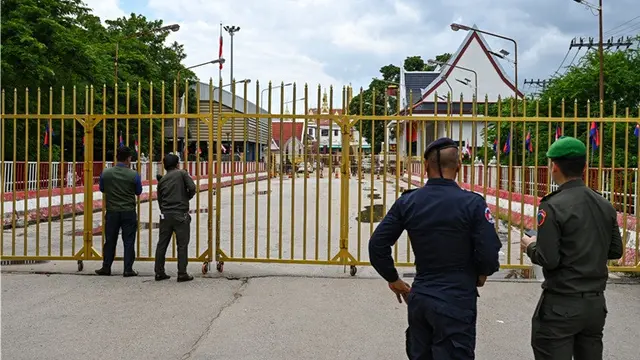 Petugas kepolisian Kamboja berjaga di depan gerbang yang ditutup di pos pemeriksaan perbatasan internasional Poipet, yang menghubungkan Kamboja dan Thailand, di Provinsi Banteay Meanchey, pada 24 Juni 2025.