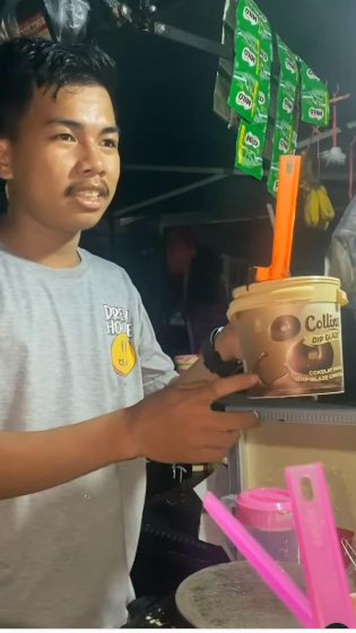"Cokelat? Cokelat? One? One? You like cheese? (Kamu suka keju)? Cheese dan cokelat?" tanyanya. <br><br>"Yes, give me one (Ya, beri aku satu)," balas sang pembeli. <br>