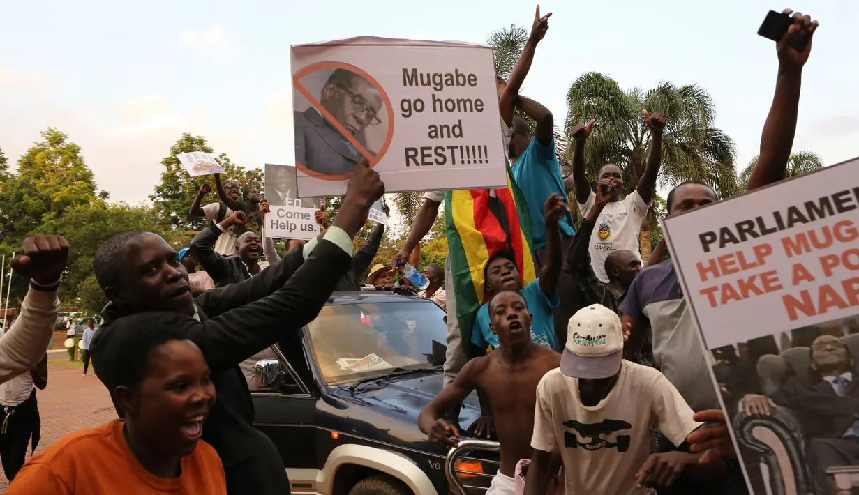 Warga Zimbabwe merayakan kabar Presiden Robert Mugabe mengundurkan diri di pusat kota Harare, Selasa (21/11). Penguasa berusia 92 tahun tersebut menyatakan mundur sesaat sebelum proses pemakzulan atas dirinya dimulai. (AP/Tsvangirayi Mukwazhi)