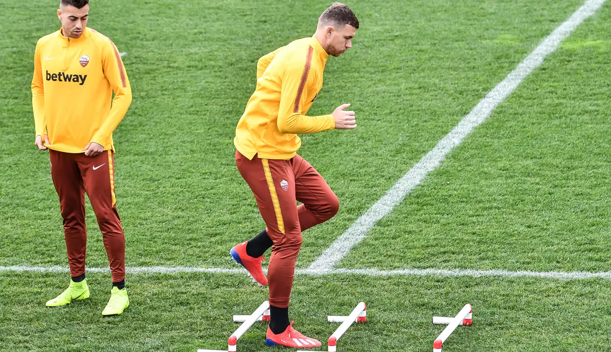 Striker AS Roma, Edin Dzeko melakukan pemanasan saat latihan di Trigoria, selatan Roma (5/3). Roma akan bertanding melawan Porto pada leg kedua babak 16 besar Liga Champions di Estadio do Dragao. (AFP Photo/Andreas Solaro)
