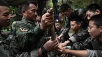 Marinir Thailand menunjukkan ular kobra yang digunakan saat latihan gabungan Cobra Gold antara militer AS dan Thailand di Chonburi, Thailand (19/2). Dalam latihan ini mereka berlatih bertahan hidup saat berada di hutan. (AFP Photo/Lilian Suwanrumpha)