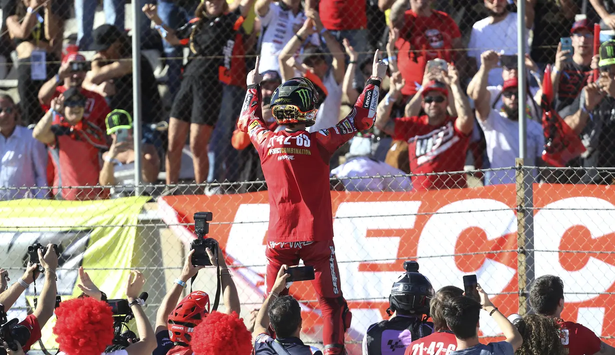 Pembalap Ducati Lenovo, Francesco Bagnaia merayakan kemenangannya di hadapan para penggemarnya saat akhir balapan MotoGP Valencia 2022 di sirkuit Ricardo Tormo, Valencia, Minggu (6/11/2022).  Ini menjadi gelar pertama pembalap asal Italia menjadi juara dunia MotoGP sejak 2009. (AP Photo/Alberto Saiz)