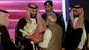 PM India, Narendra Modi memberikan bunga saat menyambut Putra Mahkota Arab Saudi Pangeran Mohammed bin Salman di bandara New Delhi, Selasa (19/2). Modi memutuskan  melanggar protokoler untuk secara pribadi menyambut Putra Mahkota Saudi. (AP/Manish Swarup)