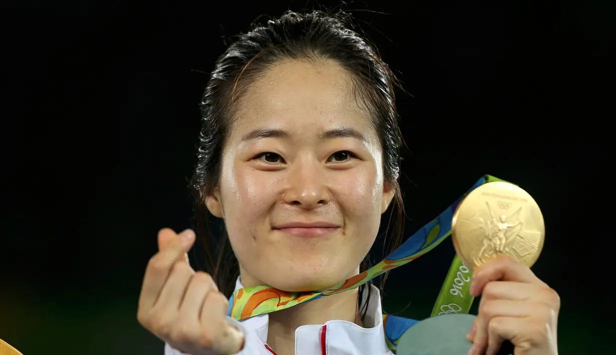 Senyum atlet Korsel, Oh Hye-Ri berpose dengan medali emasnya usai menjuarai cabang Taekwondo 67kg wanita Olimpiade 2016 di Carioca Arena 3, Rio de Janeiro, Brazil, (19/8). Atlet 28 tahun ini mengalahkan atlet Prancis Haby Niare. (REUTERS/Issei Kato) 