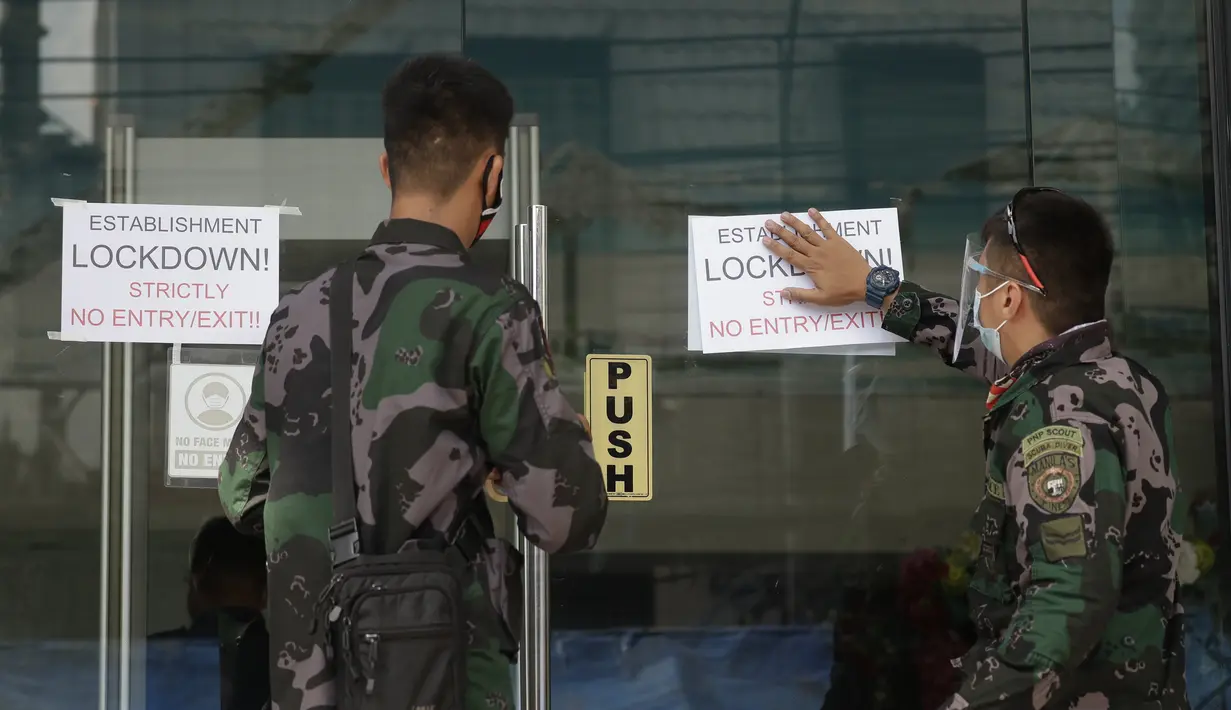 Polisi memasang tanda di luar hotel Malate Bayview Mansion yang dikunci karena jumlah kasus COVID-19 di antara penduduk di Manila, Filipina (11/3/2021). Jumlah kasus Covid-19 di Filipina merupakan yang tertinggi kedua di Asia Tenggara setelah Indonesia. (AP Photo/Aaron Favila)