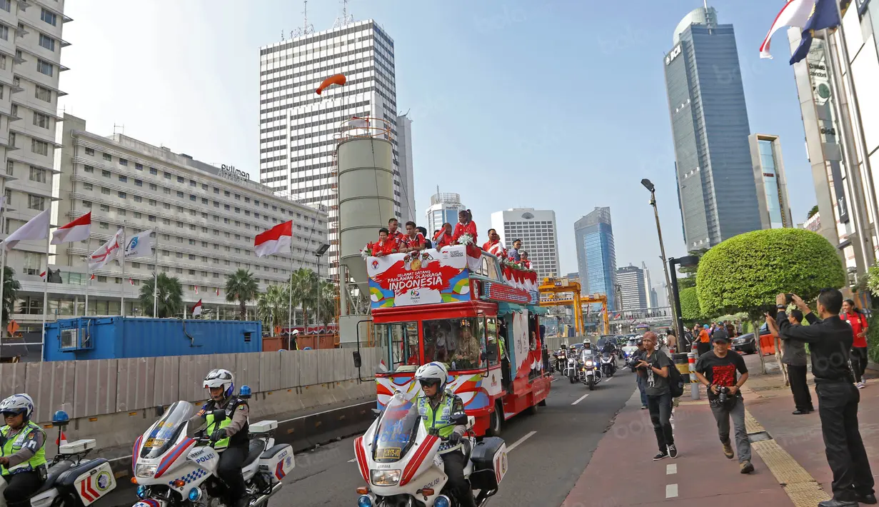 Tontowi Ahmad, Liliyana Natsir, Eko Yuli dan Sri Wahyuni melewati jalur MRT saat parade dengan bus Bandros menuju Istana Negara, Rabu (24/8/2016). (Bola.com/Nicklas Hanoatubun)