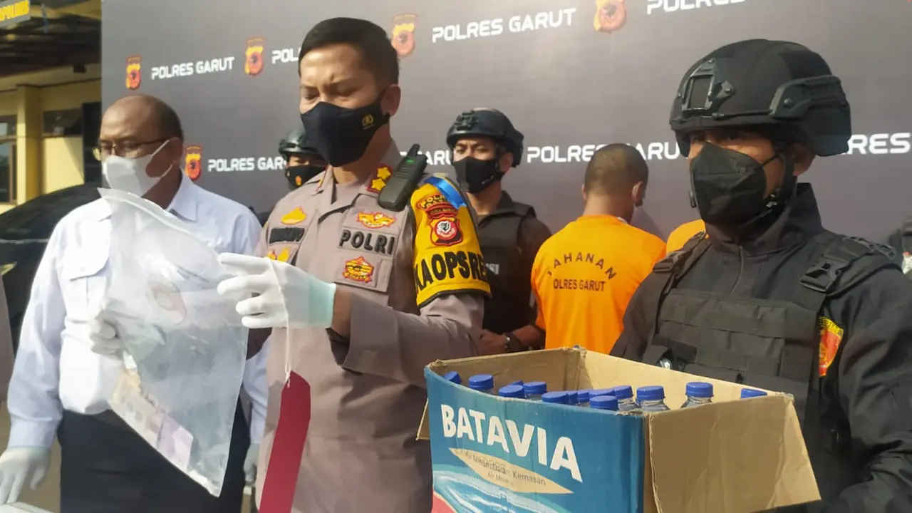 Kapolres Garut AKBP Wirdhanto Hadicaksono menujukan barang bukti dan 2 tersangka kasus punglis modus menjual air mineral dengan paksa bagi sopi angkutan.