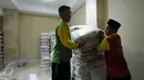 Petugas mengangkut beras zakat fitrah yang dikumpulkan dan disalurkan di Masjid Istiqlal Jakarta, Selasa (7/5/2016). Masjid Istiqlal akan menyalurkan sekitar 20 ton beras ke beberapa yayasan dan warga miskin. (Liputan6.com/Helmi Fithriansyah)