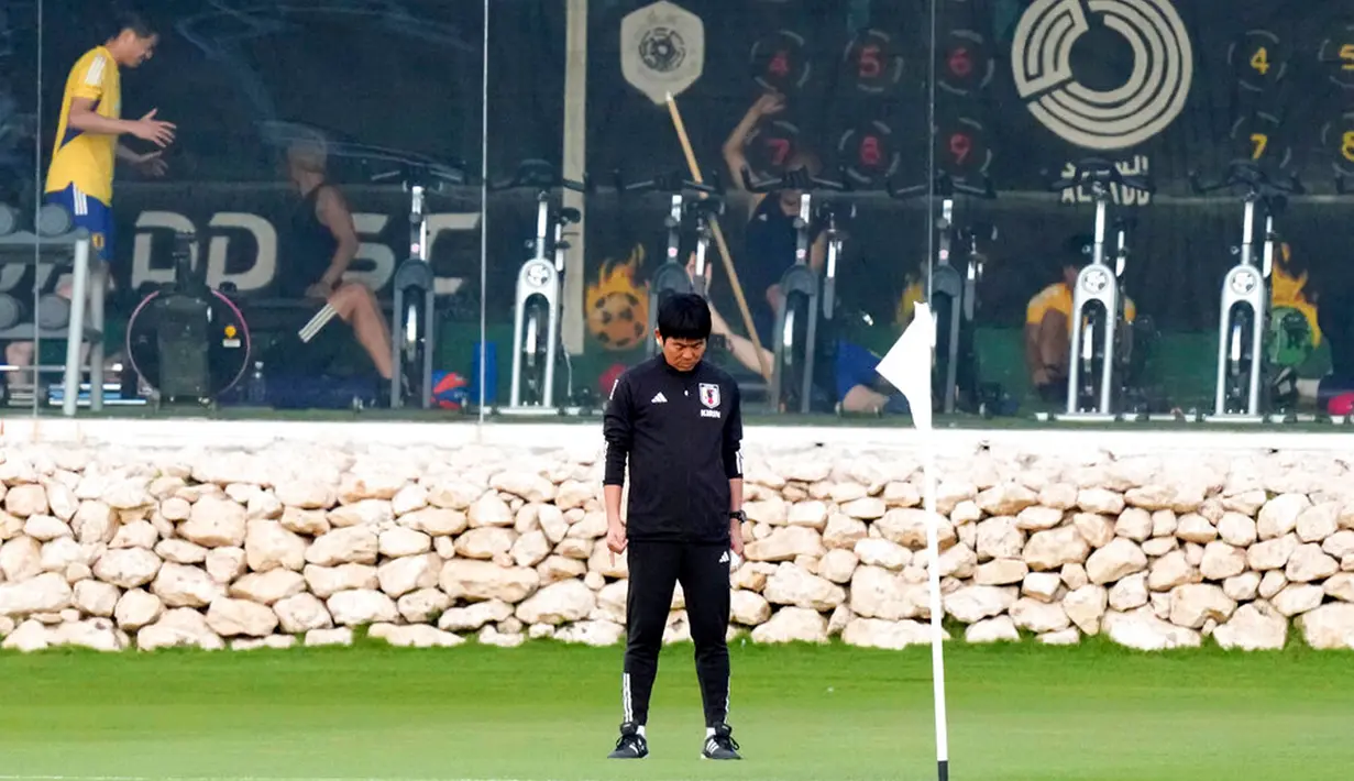 Pelatih Jepang Hajime Moriyasu berhenti sejenak di lapangan saat para pemain melakukan pemanasan di gym sebelum sesi latihan di Doha, Qatar, 29 November 2022. Jepang akan menghadapi Spanyol dalam pertandingan Grup E Piala Dunia 2022 pada 1 Desember. (AP Photo/Eugene Hoshiko)