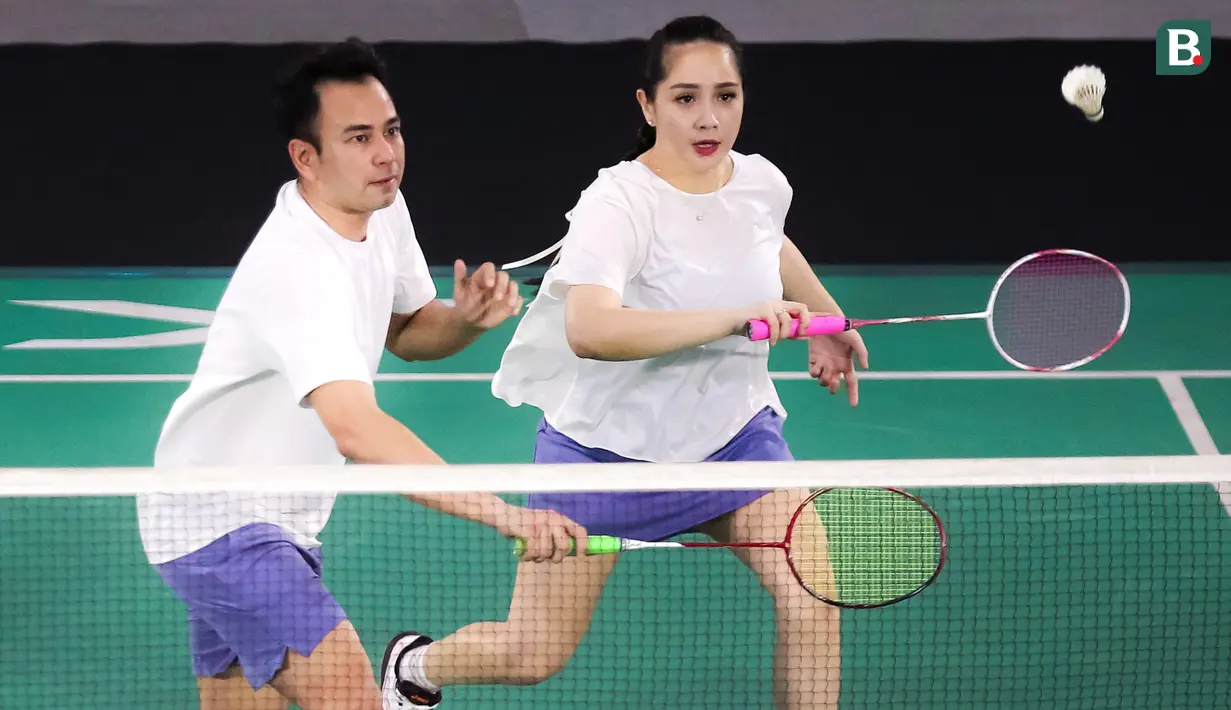Pasangan selebritas Raffi Ahmad dan Nagita Slavina berusaha mengembalikan kok saat bertanding melawan pasangan Rizky Billar dan Lesti Kejora pada laga bulu tangkis ganda campuran Turnamen Olahraga Selebriti Indonesia (TOSI) di GOR UNJ, Jakarta, Minggu (16/07/2023). Raffi dan Gigi kalah dua set langsung dari Rizky Billar dan Lesti dengan skor 12-21, 10-21.(Bola.com/Bagaskara Lazuardi)